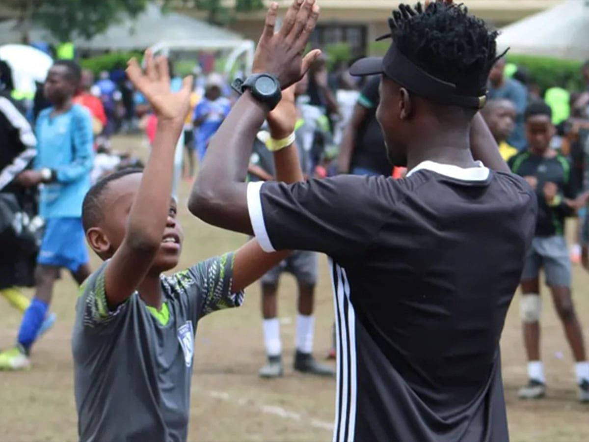 un associ&eacute; de football des ambassadeurs fait un high five &agrave; un jeune homme