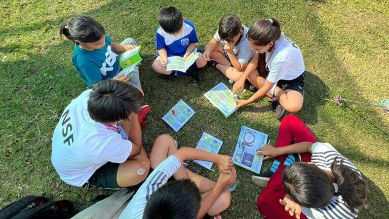 enfants lisant un livret Vers le but-v3