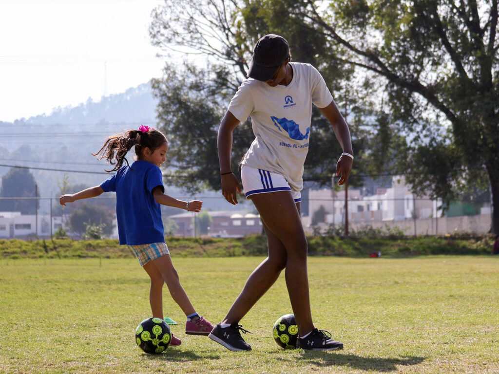 girl practicing football with coach at Ambassadors Football Mexico