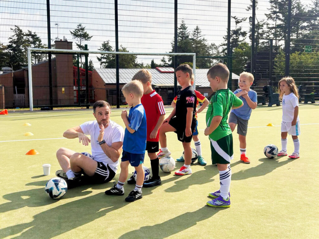 ambassadors afterschool programme-coach teaching kids football skills