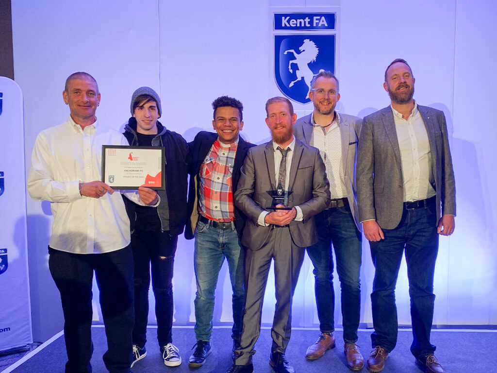 genesis football players holding trophy and certificate