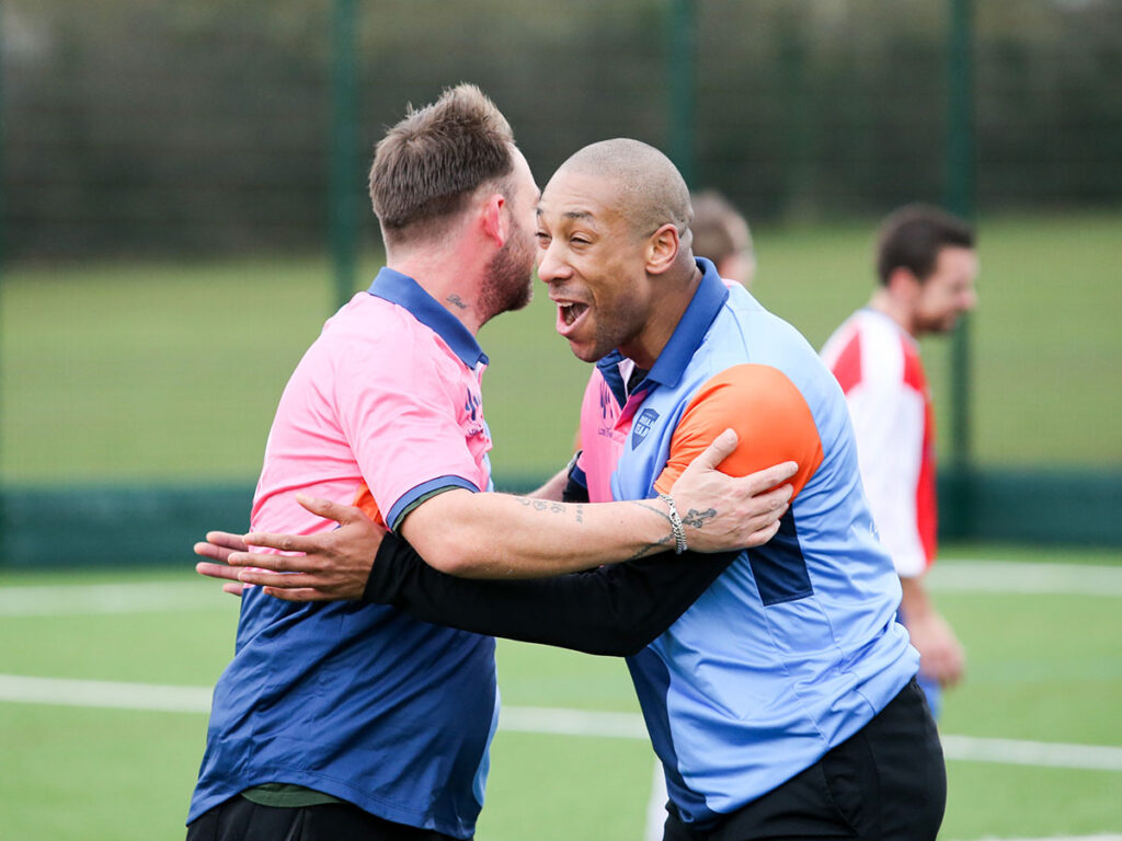 genesis football players hugging after scoring football goal