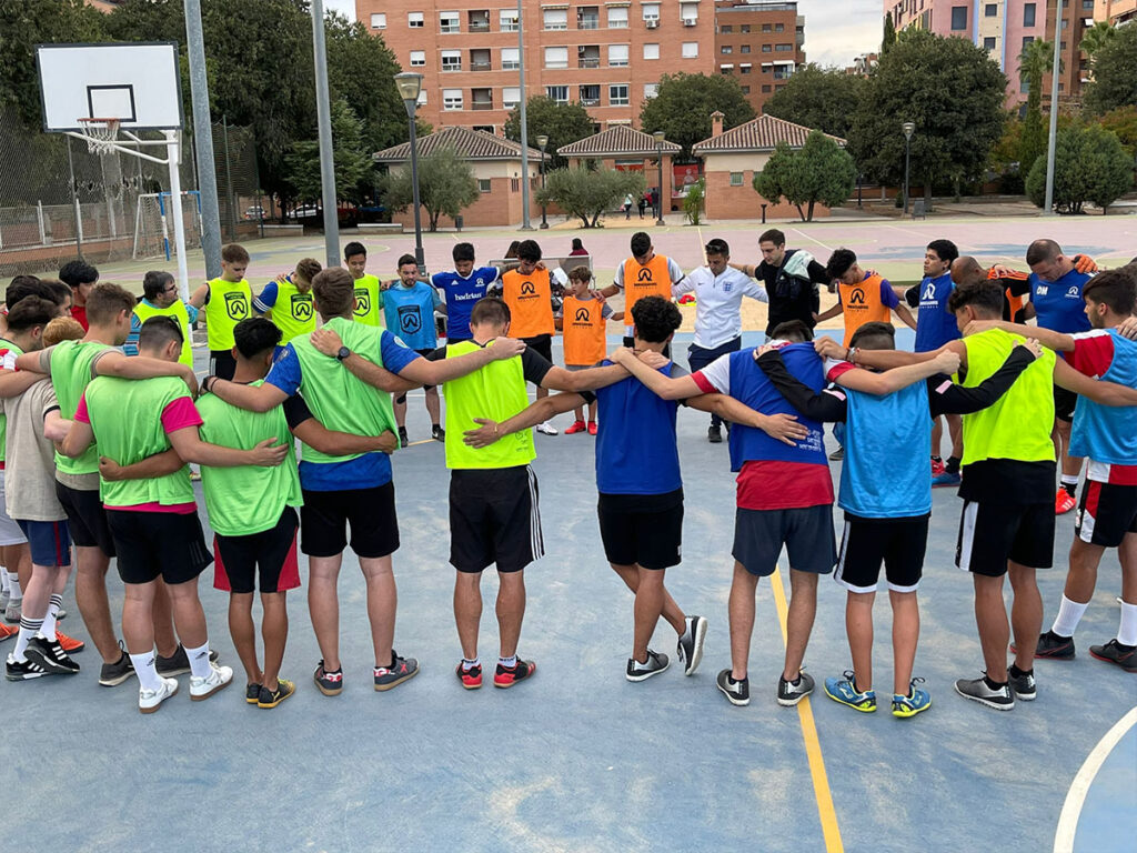 group of peple huddled in prayer on spain football tour