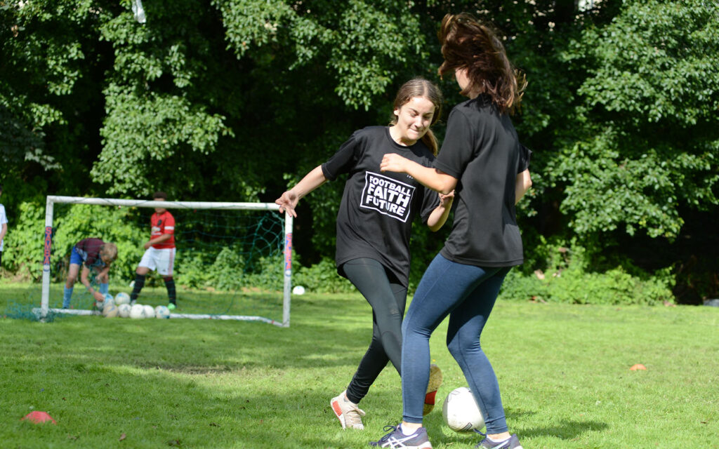 two girls playing football against each other