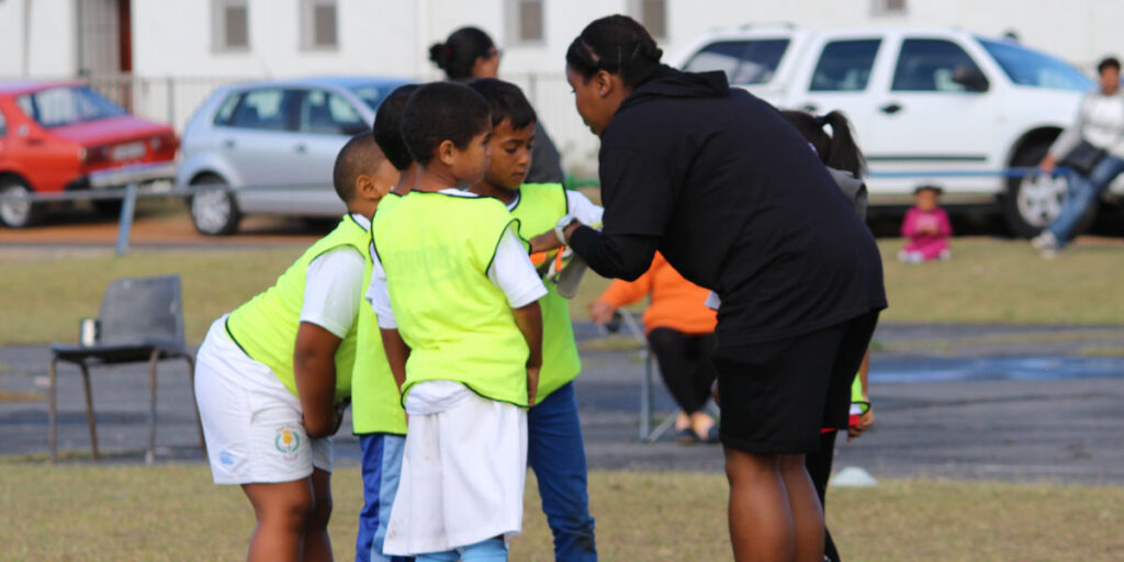 young lady volunteering time to coach kids with ambassadors football south africa