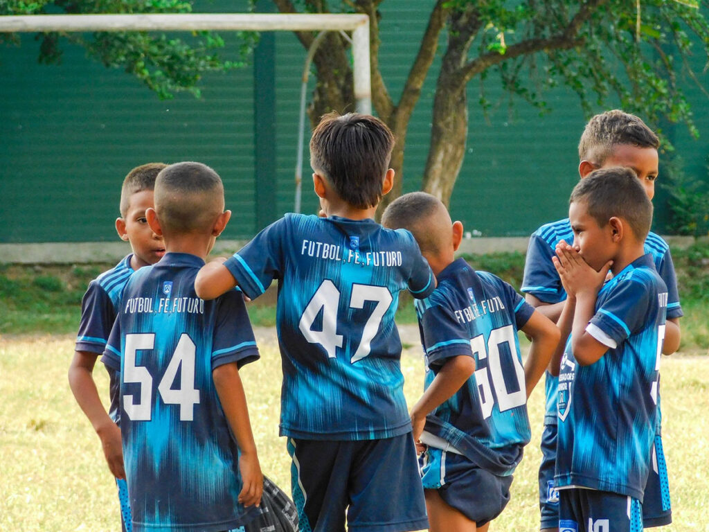 kids standing in huddle at Ambassadors Football program